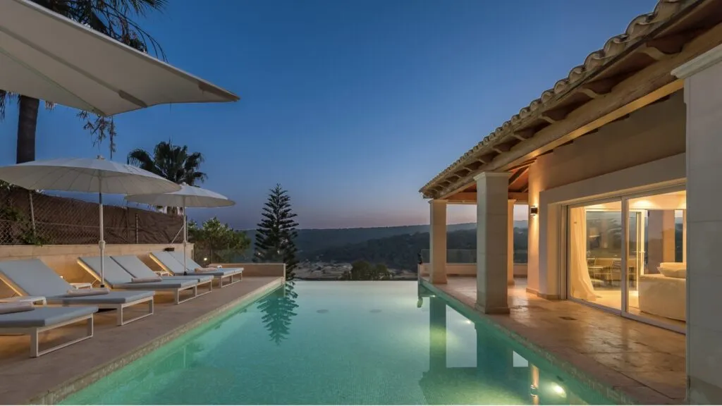 dark Sunset sky with pool and villa lit up with warm lighting